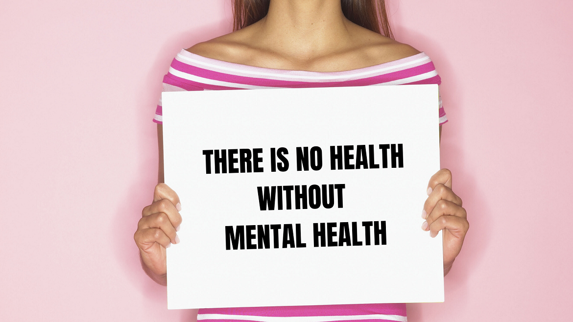 Woman holding up sign that says there is no health without mental health