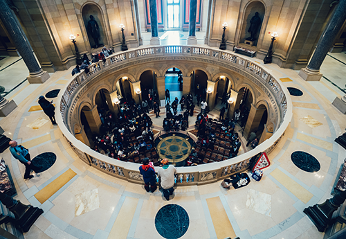 overhead shot of inside U.S. Capitol rotunda with people gathering at the bottom