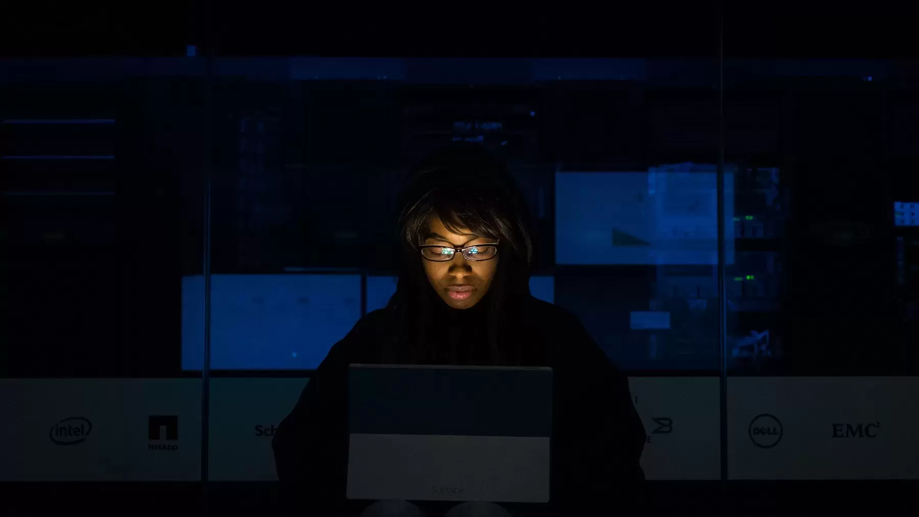 person looks at computer screen in a dark room