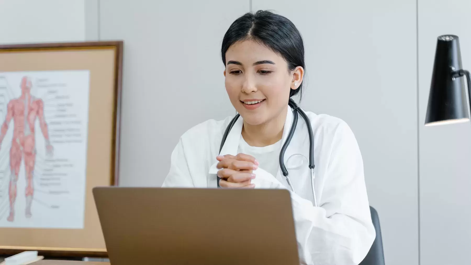 doctor is talking into laptop computer