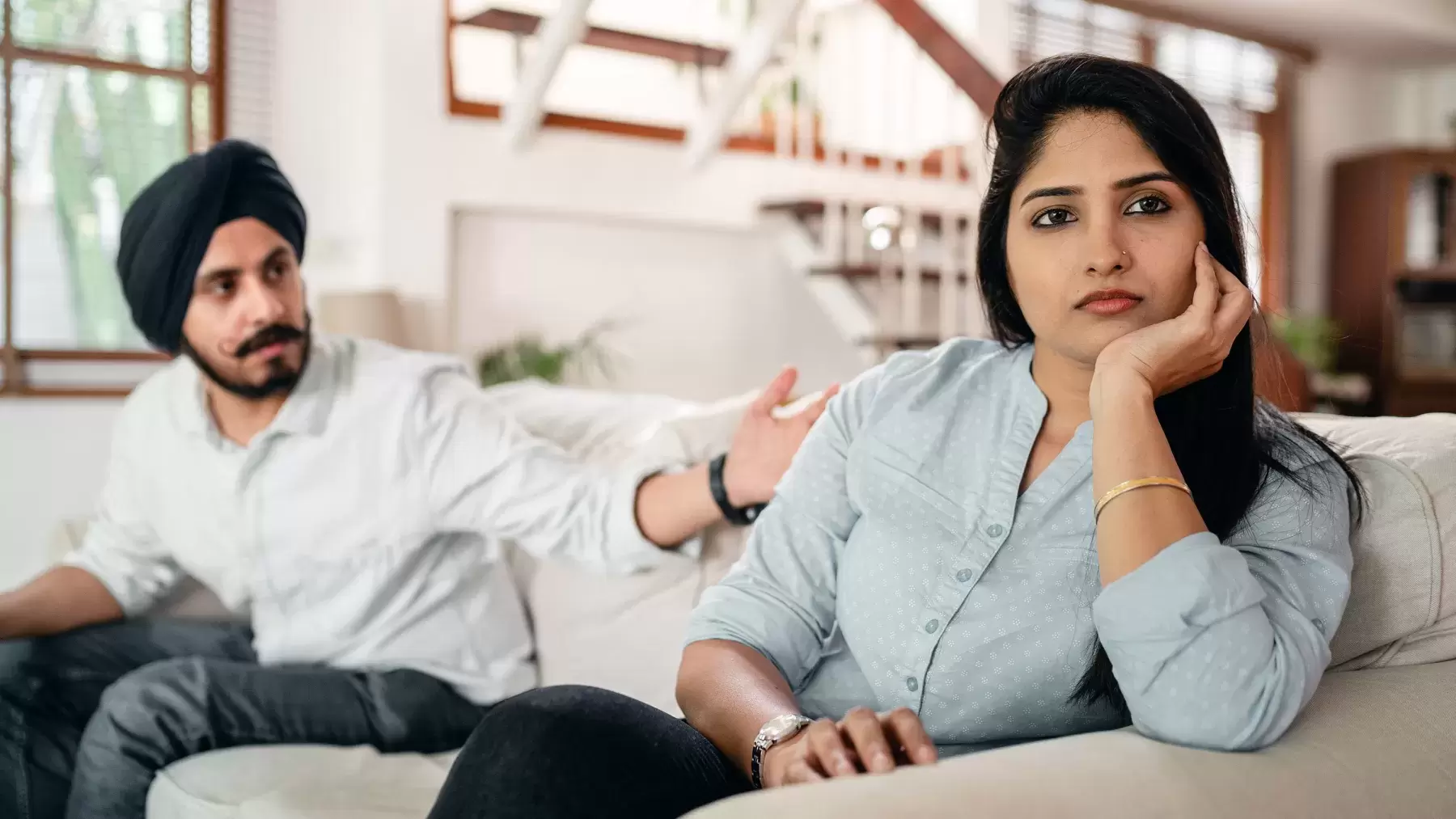 Couple sitting on couch looking upset