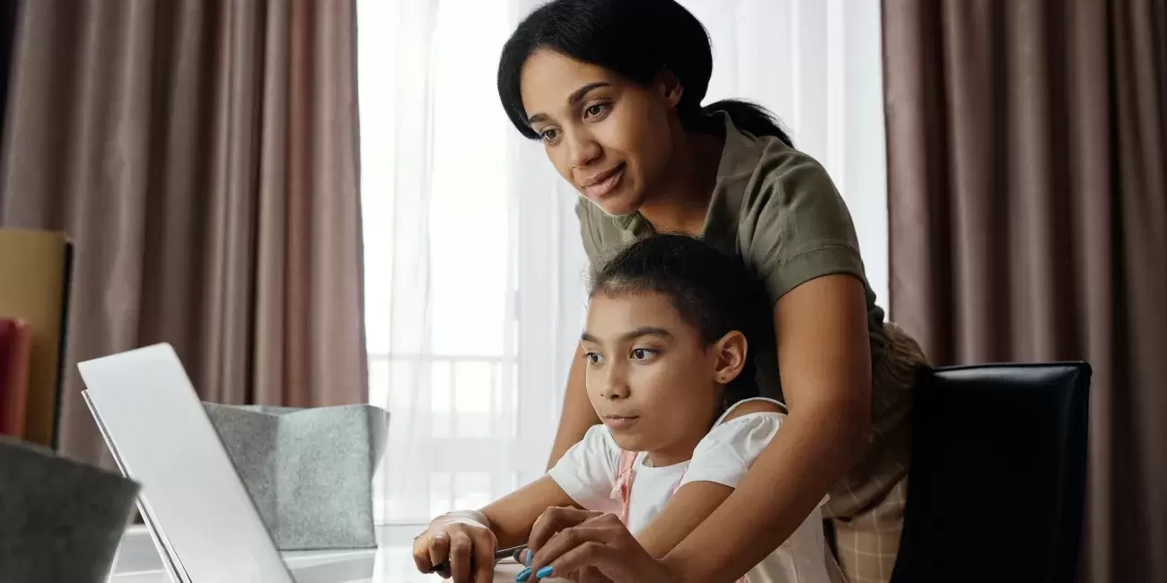 mother and child look at laptop computer together