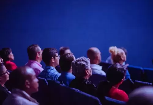 people sit in auditorium seating listening